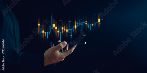 Businessman or trader is showing a growing virtual hologram stock, Planning and strategy, Stock market, Business growth, progress or success concept, invest in trading. © Looker_Studio