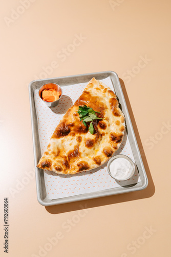 Baked Cheburek with Sour Cream-Garlic Sauce on Tray photo