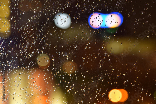 Rain drops on window blur night street wet
