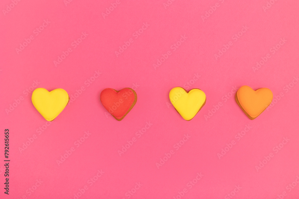 Cookies in the shape of hearts on a pink background