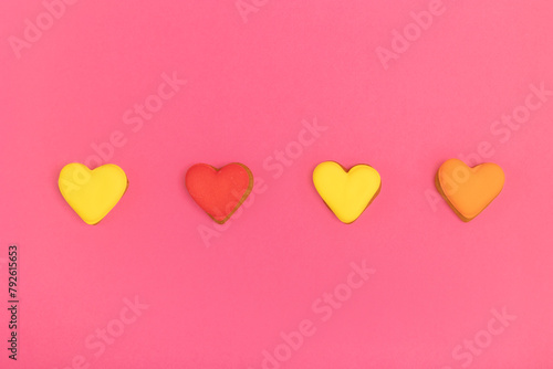 Cookies in the shape of hearts on a pink background © Olena