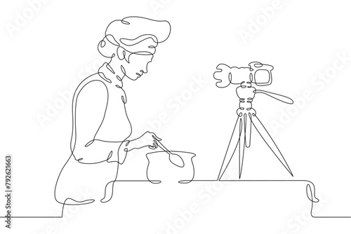 Cook is preparing food in the kitchen.Chef is in uniform.One continuous line.Blogger female character. Internet blogging, online broadcasting.Continuous line drawing.Line Art isolated white background