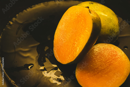 Mango fruit on the black plate,vintage color tone. Closeup of fresh chilled Mango fruit slice. Summer special