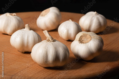 A pile of garlic on a wooden kitchen board. Organic garlic, Food background