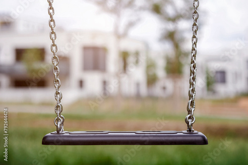 Swing on Residential Buildings Background. Empty Swing Seat. Playground Child's Swing without Children.  New Generation Problems. 