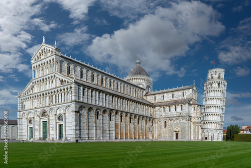 Pisa, Italy - April 05, 2024: landscape of Piazza dei Miracoli with Pisa Cathedral and the Leaning Tower under a blue sky with white clouds photo
