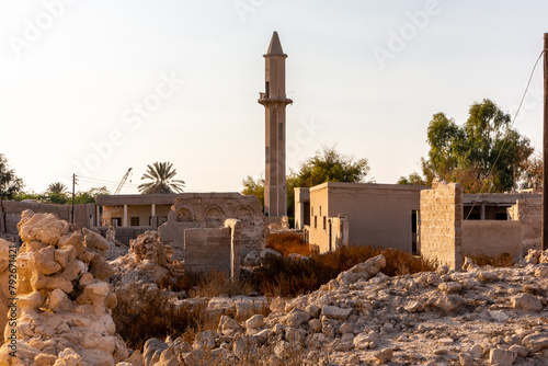 Ruined abandoned Al Jazirah Al Hamra haunted town in Ras Al Khaimah, United Arab Emirates, with demolished buildings and mosque with minaret. photo