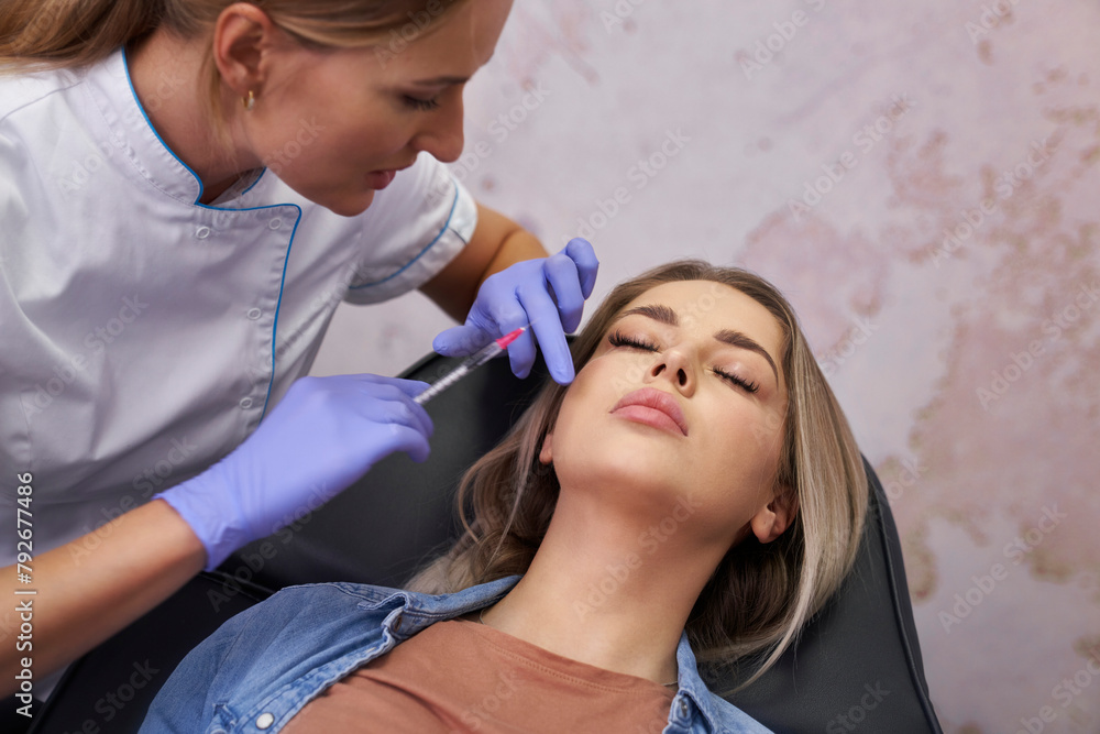Woman having facelifting procedure in beauty salon
