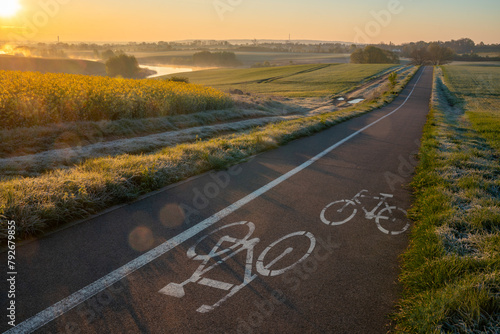 Cycle road running through beautiful spring countryside during foggy, sunny morning © Mike Mareen