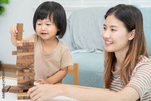 Asia Happy single mother playing learning games janga with the little boy. Funny family is happy and excited in the house. Father and son having fun spending time together. holiday, weekend, vacant.. photo