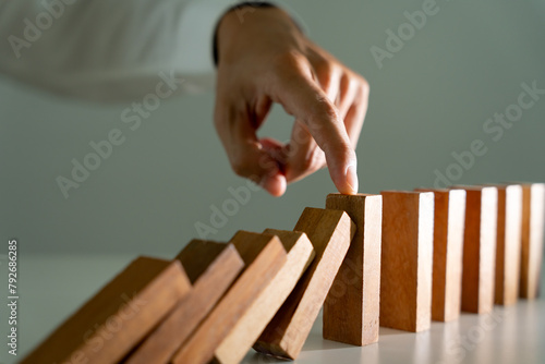 insurance with hands protect domino. Businessman hands stop dominoes falling in business crisis. business risk control and planning and strategies to run prevent insurance businesses. photo