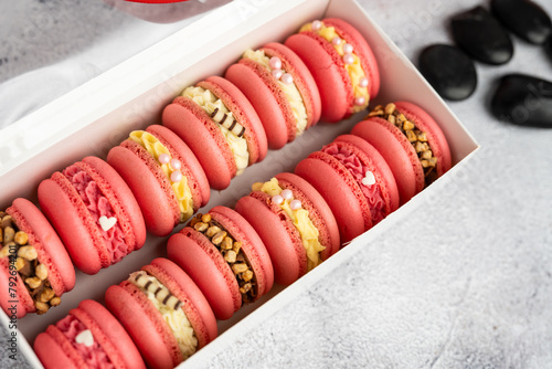 Macaroons with different fillings in a box close-up.