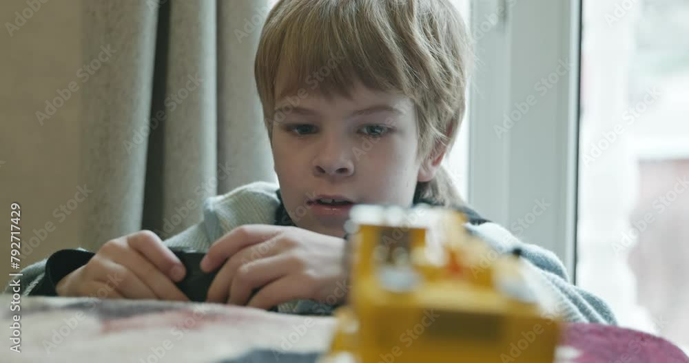 Little Kid Boy Plays Toy Excavator on Remote Control. Child Playing on Bed at Home. 4K 10-bit Little Kid Boy Plays Toy Excavator on Remote Control. Child Playing on Bed at Home. 4K 10-bit