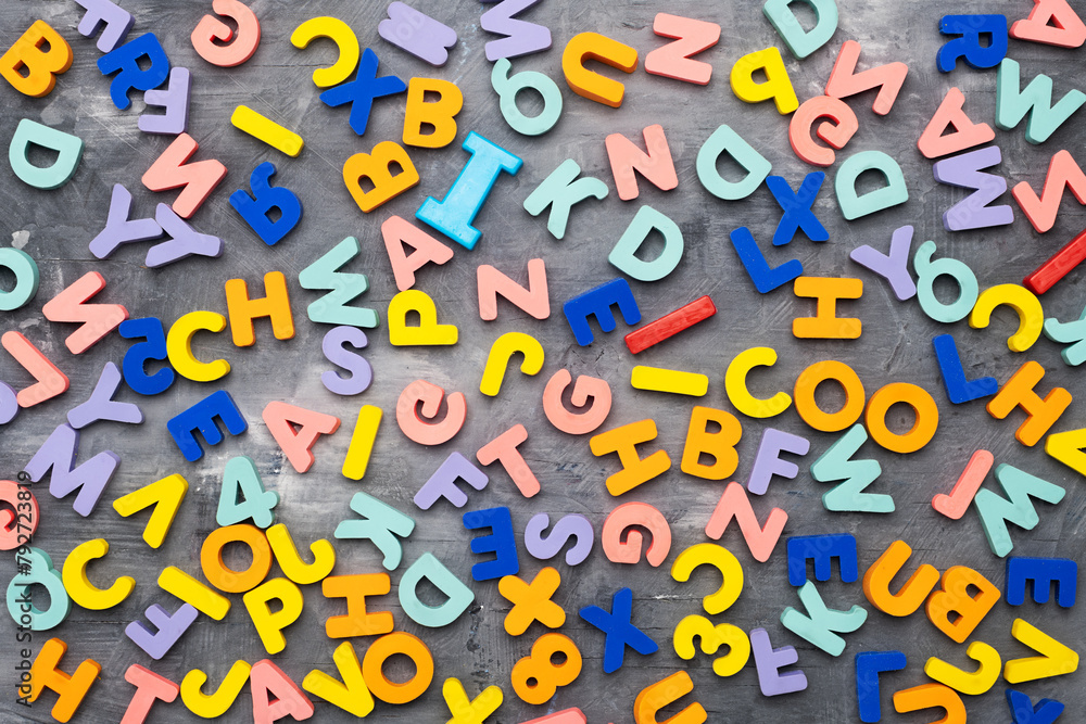 Colorful alphabet letters on gray background and texture, top view Colorful alphabet letters on gray background and texture, top view