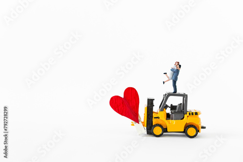 Miniature couple on forklift truck with red heart isolate on white background, love and romance, valentine concept background