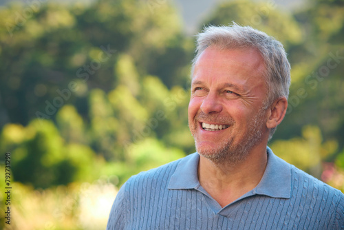Portrait Of Laughing And Smiling Mature Man Standing Outdoors In Countryside