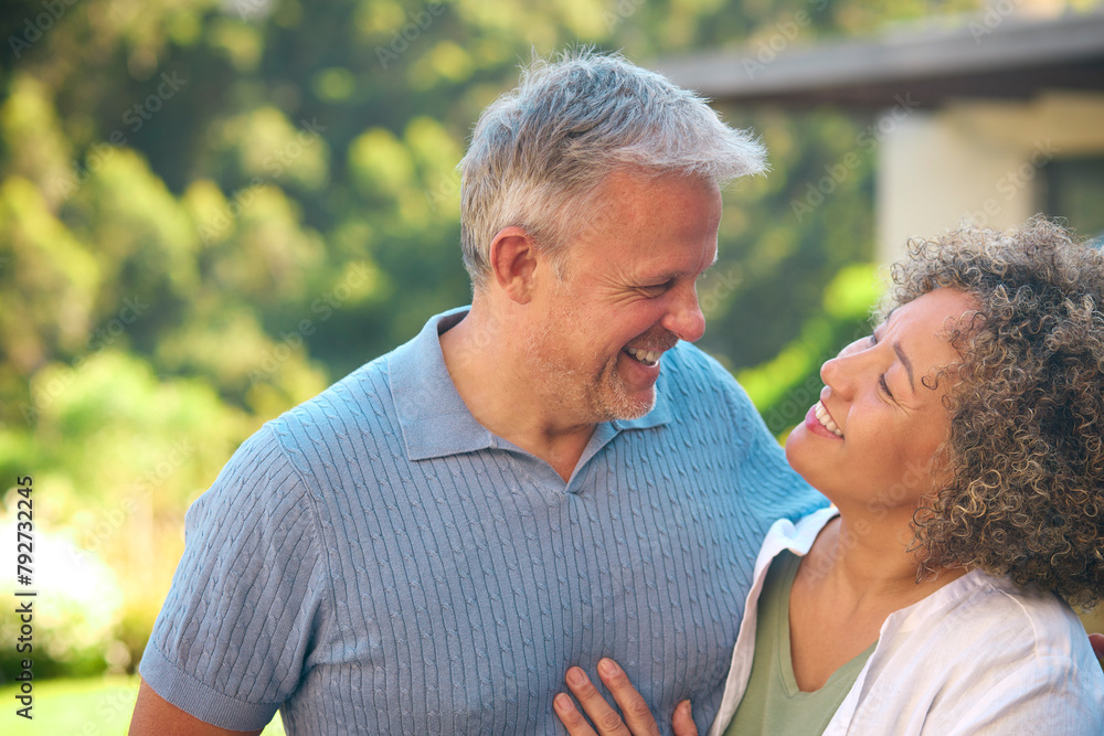 Portrait Of Laughing And Smiling Mature Multi-Racial Couple Standing Outdoors In Countryside Portrait Of Laughing And Smiling Mature Multi-Racial Couple Standing Outdoors In Countryside