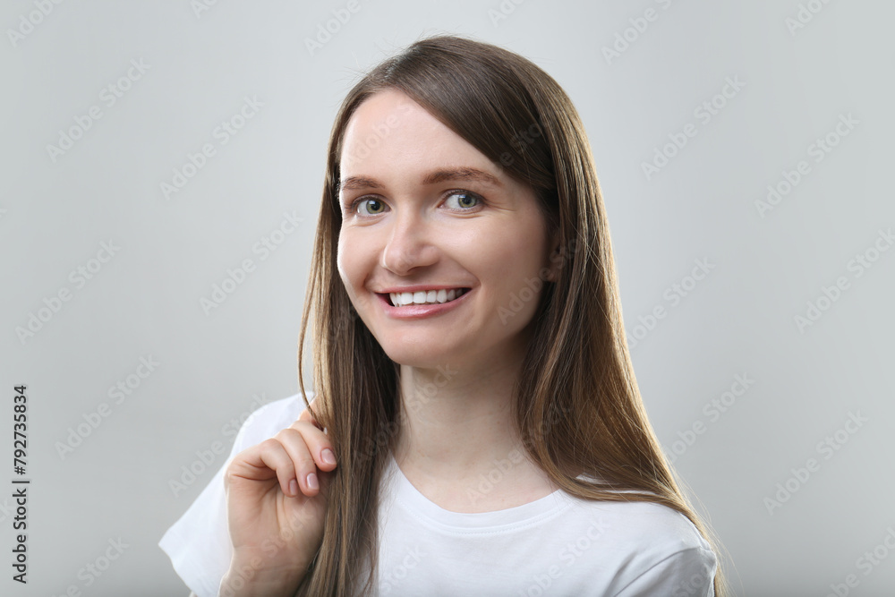 Portrait of beautiful happy woman on light grey background Portrait of beautiful happy woman on light grey background