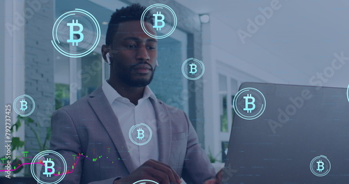 Image of data processing and bitcoin symbols over african amercian businessman using laptop