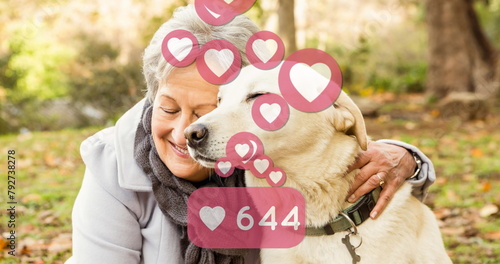 Image of social media icons with growing number over senior caucasian woman with her pet dog