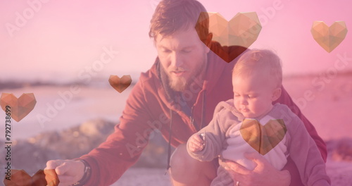 Image of heart icons over caucasian father with child at beach