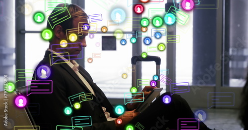 Image of profile and message icons over caucasian businessman using digital tablet at an airport