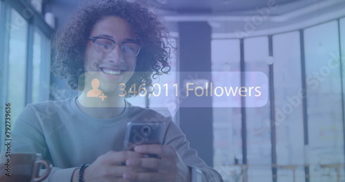 Image of followers text with growing number over biracial man using smartphone