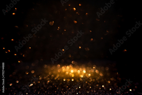 Warm golden bokeh lights illuminate a dark backdrop, creating an abstract pattern of soft glowing orbs ideal for backgrounds. Blurred shine bokeh for overlay effect.