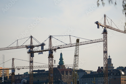 Low angle view of cranes above the city