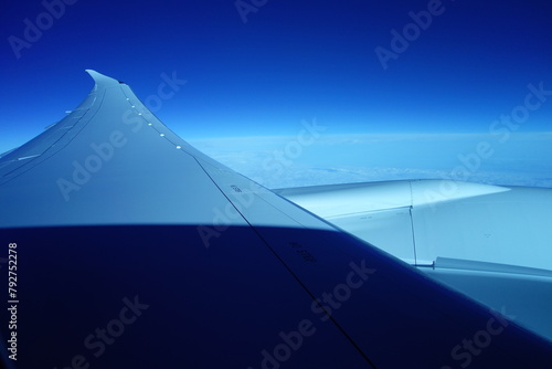 国際線の航空機の窓から見た翼と空