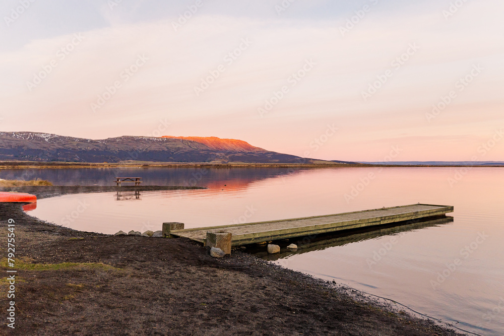Sunset aglow, tranquil lake with a serene pier