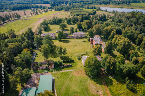 Valmiera, Latvia - August 10, 2023 - Aerial view of Katvaru manor with surrounding greenery and distant river. photo