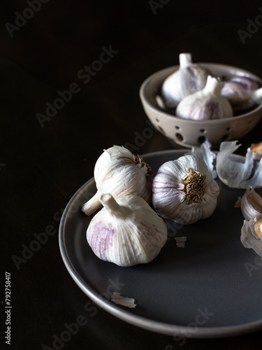 Garlic bulbs on a dark plate, moody kitchen vibes