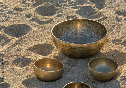 Group of tibetan singing bowl on a sand, close up