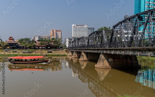 Tourist boat sailing by the Victorian era Iron Bridge in Chiang Mai,Thailand