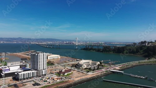 Wide angle drone shot of Treasure Island construction and The Bay Bridge midday