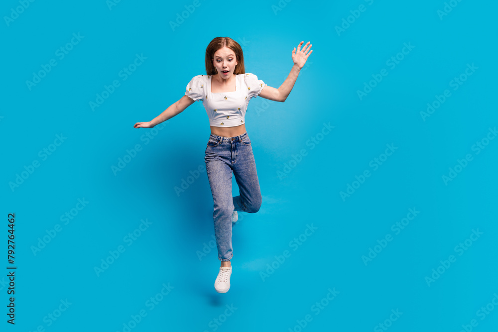 Full size photo of nice young girl jump fall empty space wear top isolated on blue color background