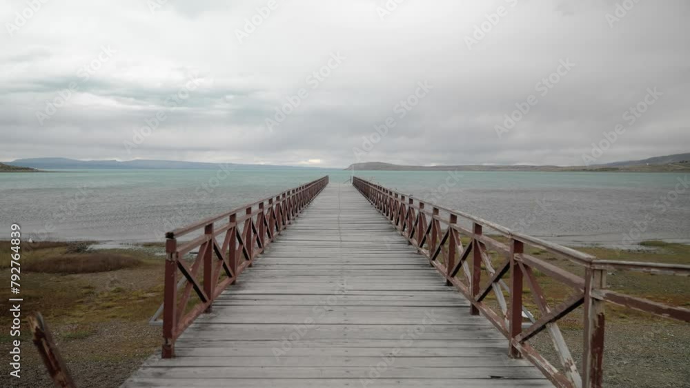 Dolly in shot of wooden pier ahead towards Argentino Lake on an overcast day Dolly in shot of wooden pier ahead towards Argentino Lake on an overcast day