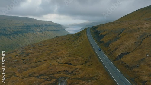 Scenic Drive: Aerial Cinematography of Car Moving Through Spectacular Faroe Islands Landscape with Drone. photo