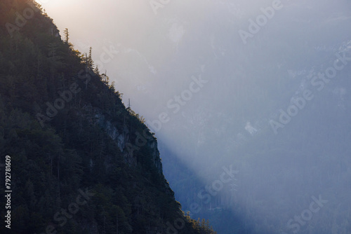 Avondzon over een naaldbomenrijk berghelling in Oostenrijk photo