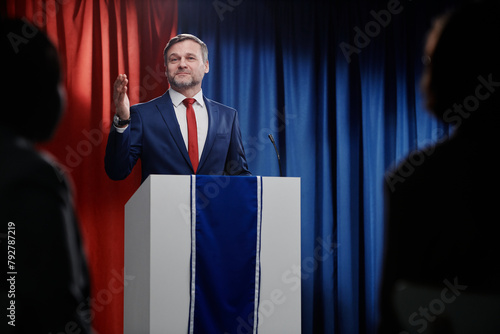 Mature male deputy or candidate for post of American president looking at journalists or electorate during his speech by platform © pressmaster