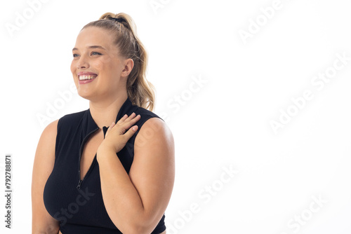 Blonde plus size model laughs, touches shoulder, on white background