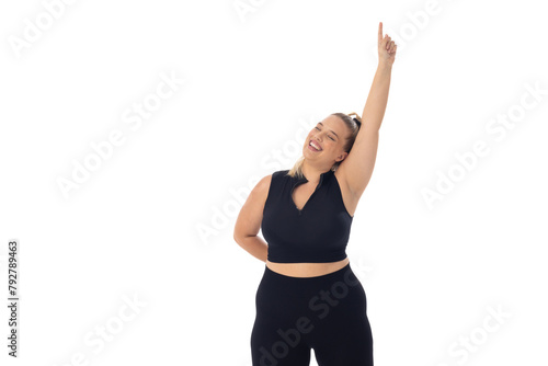 Caucasian plus-size young woman in black sportswear on white, pointing up