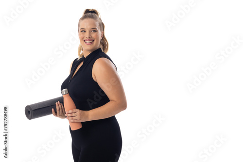 Caucasian young female plus size model with white background holds a yoga mat, copy space