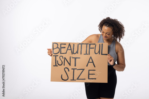 Biracial young female plus size model holds poster on a white background