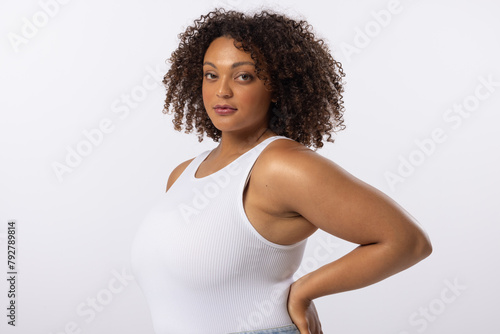 A biracial young female plus size model poses on white background, copy space