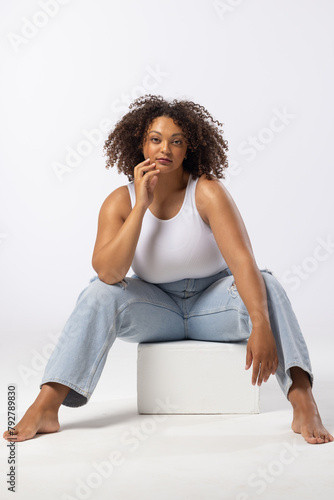 Biracial plus size model sits on white background
