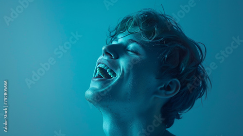 Playful man in turquoise, laughing with abandon.