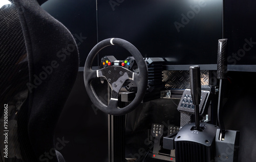 DIY high end simracing aluminum carbon fiber simulator rig for video game sim racing. Black CFK car bucket seat steering wheel shifter pedals and tripe screen setup dark background