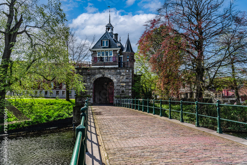 View of the renaissance architecture Oosterpoort gate from the golden age and adjoining bridge in the Dutch city of Hoorn under a blue clouds sky in spring.	 photo
